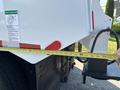 A 2013 International WorkStar truck with a measuring tape extending to the rear side of the vehicle showing measurements on the tape