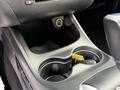 A close-up view of the center console area in a 2013 Dodge Journey featuring cup holders and a power outlet