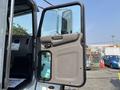 A 2020 Peterbilt 330 truck with its driver's side door open showcasing the interior design and controls