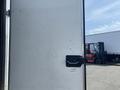A 2008 Wells Industries Inc EW1422 trailer door partially open showing a metal surface with a handle and latch visible
