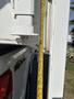 A close-up view of a measuring tape next to a white panel of a 2018 Westland Travelaire showing the measurement and attachment points