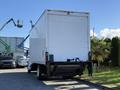 A 2012 Freightliner M2 106 box truck with a white cargo area and black chassis parked in a lot