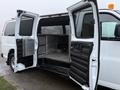 A 2016 GMC Savana with open rear doors revealing a spacious interior suitable for cargo or equipment transport