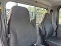 Two grey fabric seats inside a 2020 Peterbilt 330 truck cabin with a simple design and adjustable headrests