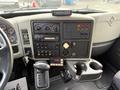 Dashboard of a 2013 International Durastar 4300 featuring gauges controls switches and a gear shifter with a cup holder in view