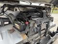 A 2012 Ford E-450 Super Duty engine with visible components including wires and a battery unit