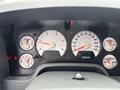 Dashboard of a 2006 Dodge Ram 2500 showing speedometer tachometer fuel gauge and additional dials with warning lights illuminated