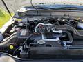 A 2010 Ford F-450 engine with various hoses and components visible includes a large air intake and battery units on either side