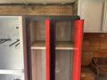 An open cabinet with red doors on a Workhorse W62 vehicle showing empty shelves inside