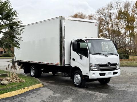 A white 2019 Hino 195 box truck with a large cargo area and chrome accents parked at an angle with its front facing slightly to the left