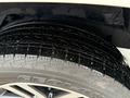 Close-up of a wet tire tread from a 2018 Toyota 4Runner showing deep grooves and a rugged design for traction on various surfaces