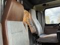 Two truck seats in a 1996 Kenworth T800 with gray fabric and brown leather accents, positioned side by side inside the cab