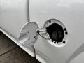 A white 2011 Chevrolet Colorado with the fuel door open revealing the fuel cap inside