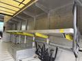 Interior cargo area of a 2012 Ford Econoline featuring aluminum shelving with yellow edges and straps for securing items