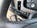 Close-up of a turn signal lever inside a 2020 Peterbilt 330 truck with various controls and gauges visible in the background