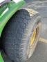 Close-up of a large, treaded tire from a 2008 John Deere 3320 300X showing deep grooves and worn rubber