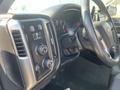 Dashboard and controls of a 2015 Chevrolet Silverado 1500 featuring buttons for various functions and a visible steering wheel