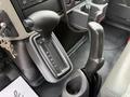 The gear shift lever of a 2012 International TerraStar with gear indicators for park reverse neutral and drive alongside a parking brake lever and cup holder