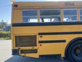 A yellow 2006 Thomas Saf-T-Liner HDX school bus showing the rear side with windows and a grid pattern near the back wheel