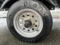 Close-up of a tire and wheel from a 2009 ShoreLandr ANDER trailer showing the tread pattern and wheel rim with visible wear and dirt