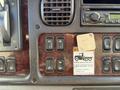 Dashboard controls of a 2012 Freightliner M2 106 featuring multiple buttons for locks heating and safety warnings