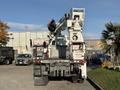 A 2011 International 7500 utility truck with a raised aerial lift and various equipment mounted on the bed