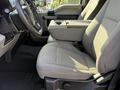 A 2021 Ford F-250 SD interior showing the front seats and center console with fabric upholstery in gray