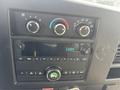 Dashboard controls of a 2018 Chevrolet Express featuring climate controls audio system and clock display