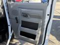 The image shows the interior driver's side door panel of a 2019 Ford E-450 featuring a gray handle and storage compartments with the E-Series logo