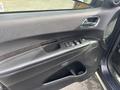 Interior door panel of a 2015 Dodge Durango featuring controls for the windows and side mirrors along with a speaker and textured trim