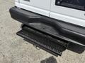 A black retractable step attached to the rear of a white 2008 Ford Econoline van
