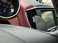 Interior view of a 2016 Maserati Ghibli with a focus on the steering wheel paddle shifter and dashboard display showing various gauges and controls