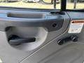 The interior door handle of a 2019 Freightliner M2 106 with a warning label and two knobs for adjustments
