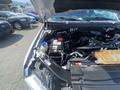The engine compartment of a 2015 Ford F-150 showcasing the battery and various engine components