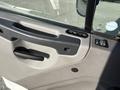 Close-up of the door handle and control panel of a 2022 Freightliner M2 106 truck showing textured gray material and black plastic components