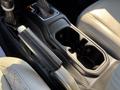 Interior center console of a 2021 Jeep Gladiator featuring gear shifter and cup holders