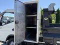 A 2015 Mitsubishi Fuso FE with an open metal storage compartment displaying shelves inside
