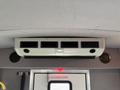 A ceiling-mounted air conditioning unit with vents and speakers inside a 2014 Ford Econoline van