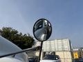 A 2010 Freightliner M2 106 is reflected in a side mirror showing the front of the truck and part of its cabin