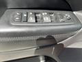 Close-up view of the driver's side window control panel of a 2015 Jeep Grand Cherokee featuring buttons for window operation and door locks