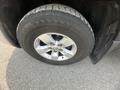 Close-up of a silver alloy wheel with a black tire on a 2015 RAM 1500
