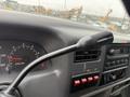Close-up of the gear shift lever and dashboard controls in a 2000 Ford F-450 featuring the overdrive switch and gauges
