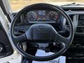 The steering wheel of a 2015 Hino 358 truck featuring various buttons and controls along with a dashboard displaying gauges and a digital screen
