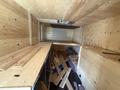 Interior view of a 2009 Workhorse W62 featuring wooden panels and scattered lumber along the floor