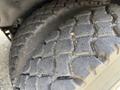 Close-up of a heavily treaded tire from a 1996 Kenworth T800 showcasing worn rubber and deep grooves designed for traction
