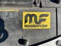 A yellow Magnaflow sticker featuring the initials MF on a vehicle component