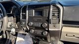 Interior dashboard of a 2016 Ford F-150 featuring radio controls climate settings and various buttons and knobs for vehicle functions