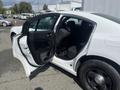 A white 2017 Dodge Charger with a partially open door showcasing the interior seating and dashboard