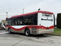 A 2016 Grande West Vicinity bus with a white and red exterior design viewed from the rear right side