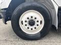 Close-up of a tire mounted on a wheel of a 2006 Freightliner M2 106 featuring a multi-bolt pattern and a wide tread designed for heavy-duty use